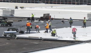 Workers placed 712,000 board feet of 2-inch cellular glass insulation over concrete roof channels, followed by 1,086 rolls of 90-mil membrane in hot asphalt. The fleece-backed membrane with air-welded seams produced an integrated roof system backed by a 30-year warranty.